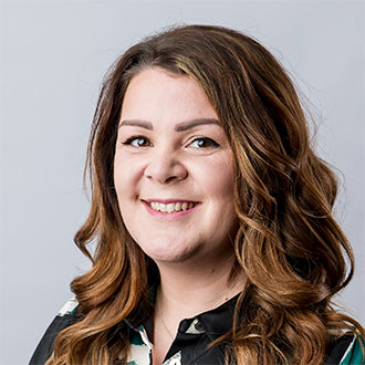 person with long wavy hair smiling at the camera