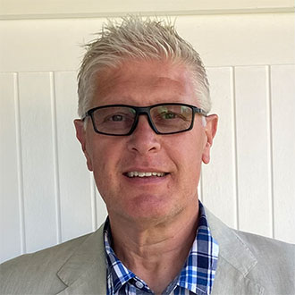 person in glasses smiling at the camera