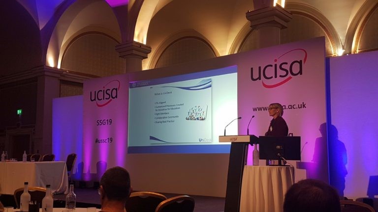 Colour photograph of a presenter at ucisa SSG19 presenting to a room of people